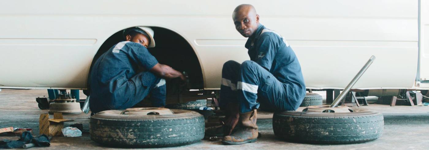 Mechanics servicing a vehicle in a Nigerian workshop